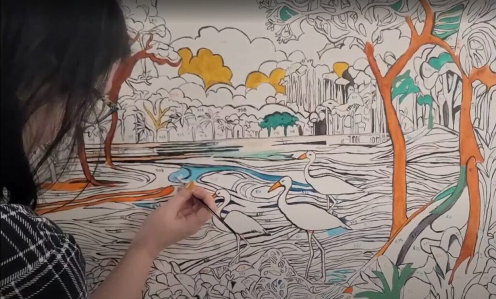 Close view of woman's hand painting a section of water on a custom paint by numbers canvas.